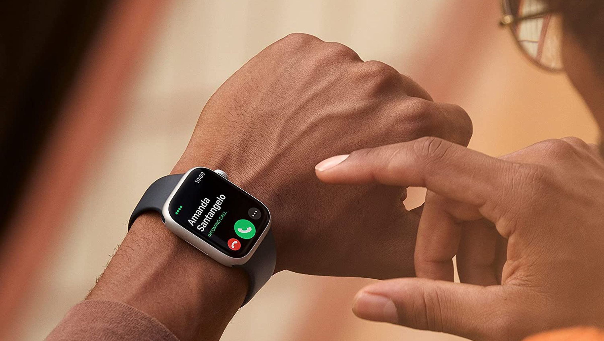Somebody wearing and about to tap on the Apple Watch Series 8.